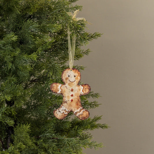 Gingerbread man ornament hanging on a Christmas tree