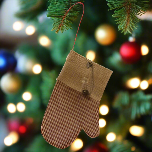 A gingham fabric ornament with a burlap cuff, a rusty metal safety pin, and a jingle bell, designed to hang on a metal hook.