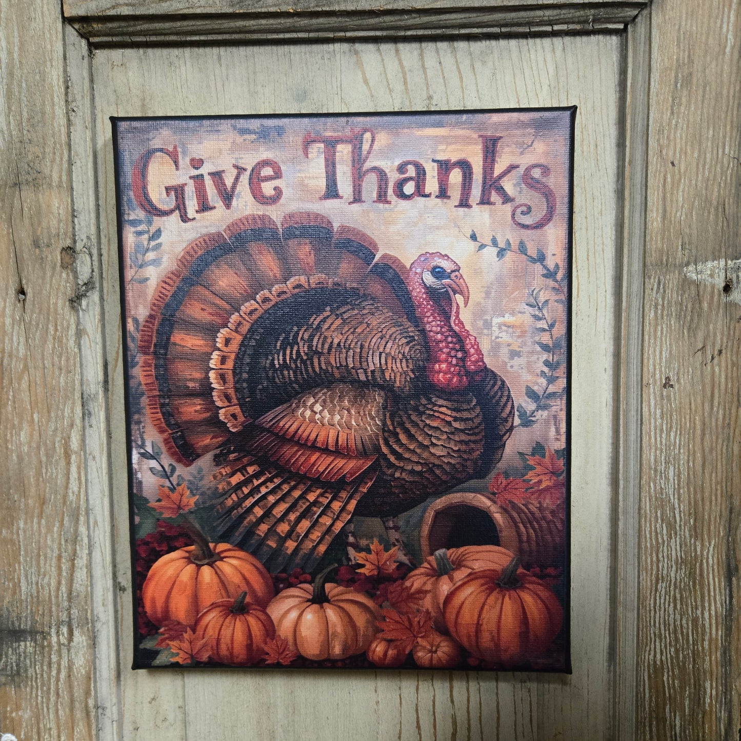 Framed artwork with a turkey and pumpkins on a rustic wooden background
