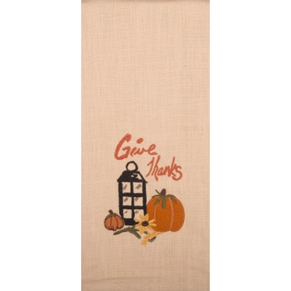 A beige hand towel with a 'Give Thanks' text and a lantern with pumpkin design.