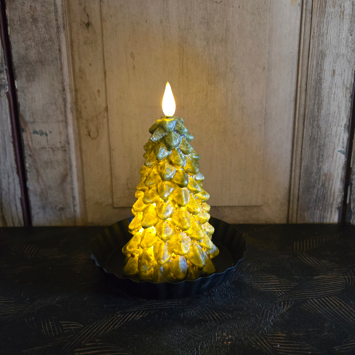 Battery-operated tree candle on black riser.