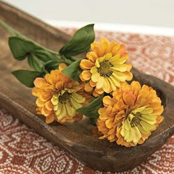 Three yellow flowers in a wooden bowl on a patterned surface
