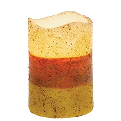 Multicolored candle with speckled texture on a white background