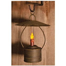 A rustic reproduction lantern with a distressed black metal base and a circular wire frame handle, featuring a removable flat shade and a built-in grungy wax LED taper.