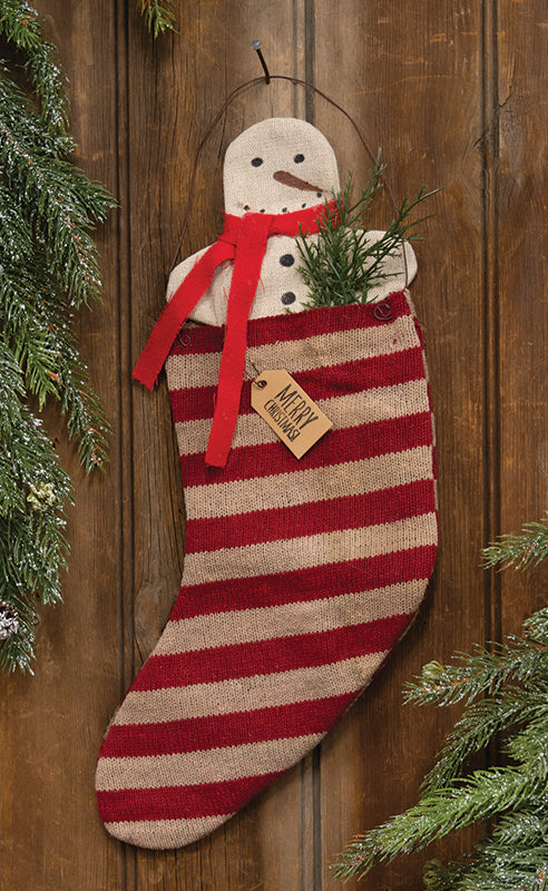 Striped stocking holding snowman and greenery inside