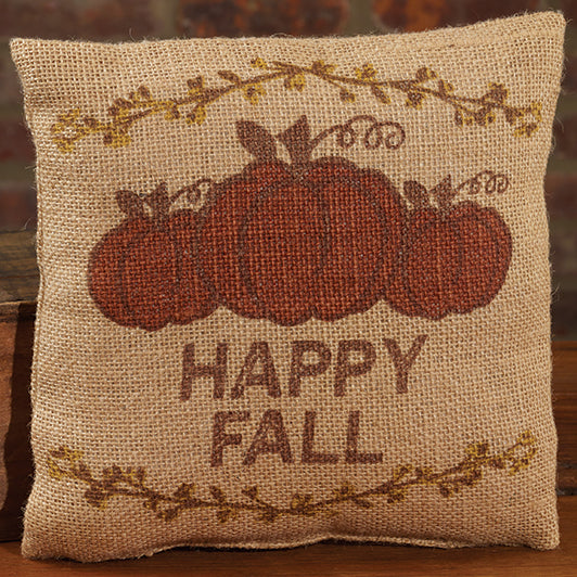 Decorative pillow with pumpkins and 'Happy Fall' text on a burlap-like background.