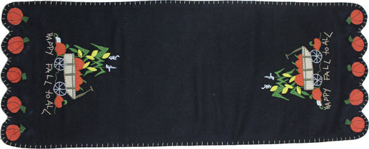 A black table runner with embroidered pumpkin and leaves design and the text 'Happy Fall to All'.
