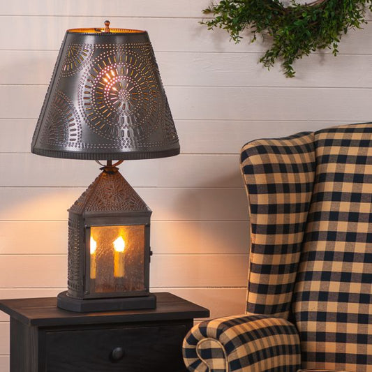 Decorative lantern-style table lamp on a wooden side table with a checkered chair in the background.