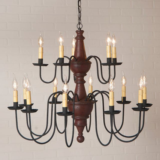 Vintage-style chandelier with wooden center and black metal arms against a light brick wall.