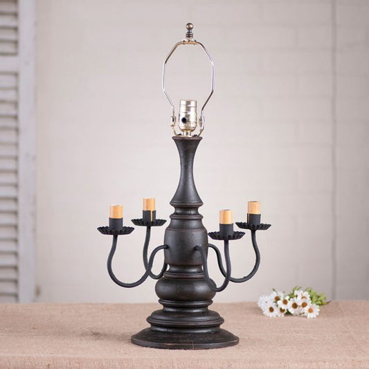 Decorative black candelabra with lit candles on a neutral background