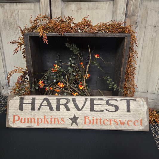 Decorative sign with 'Harvest Pumpkins Bittersweet' text next to a wooden box with autumnal decorations.