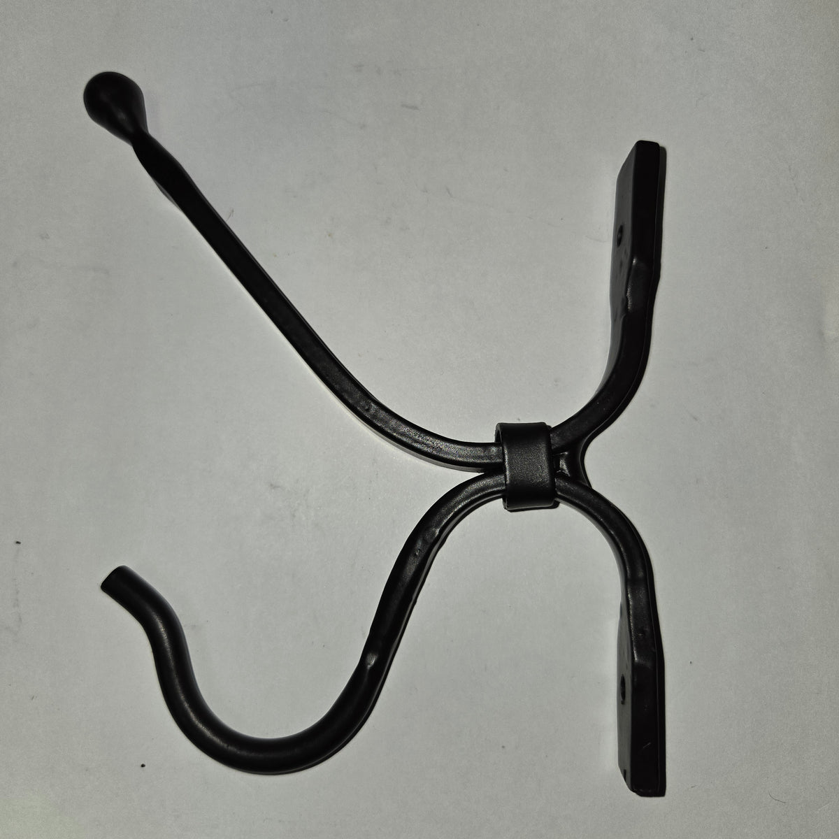 Black metal hook on a light gray background