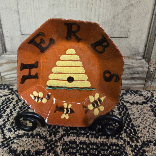 Octagonal redware plate with bee skep motif with the word 'HERBS'