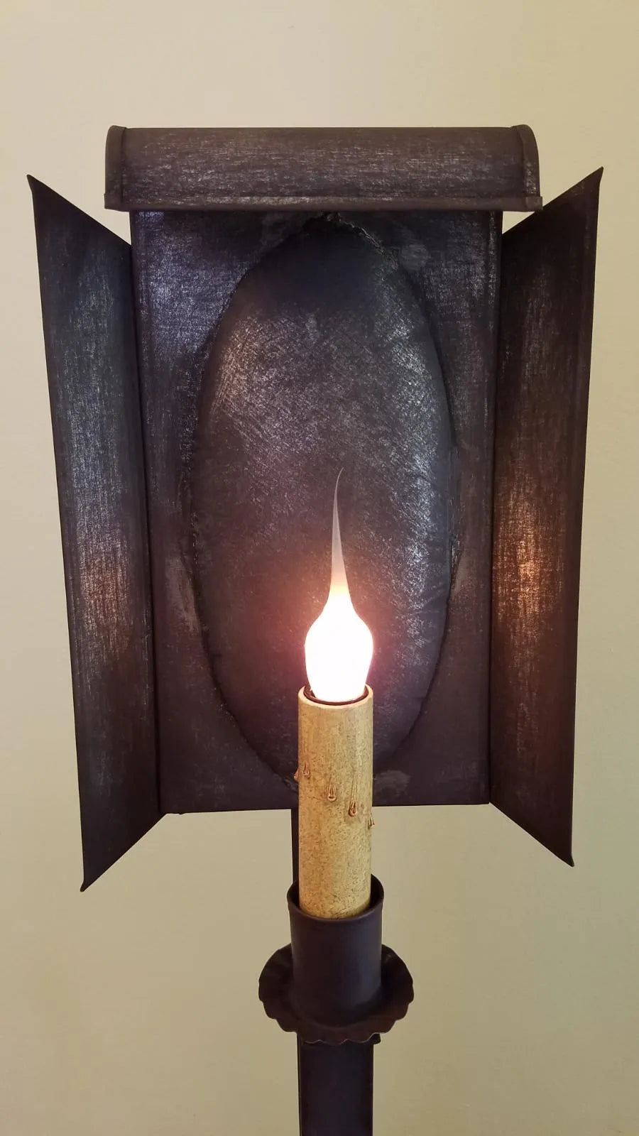 Close up view of tin lamp with geometric reflector pan.
