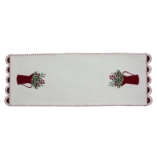 A cream-colored table runner with a pitcher design and red trim, suitable for holiday dining tables.