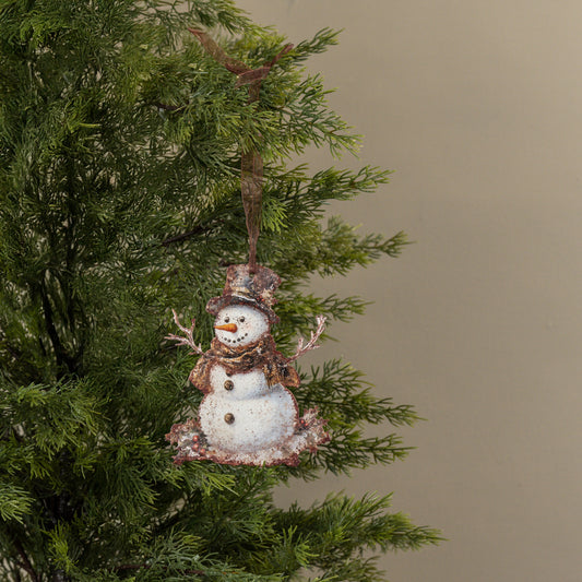 Decorative snowman ornament hanging on a Christmas tree with a plain background