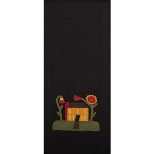 A black hand towel with a rural or nostalgic design featuring a house, flowers, and a sunflower.