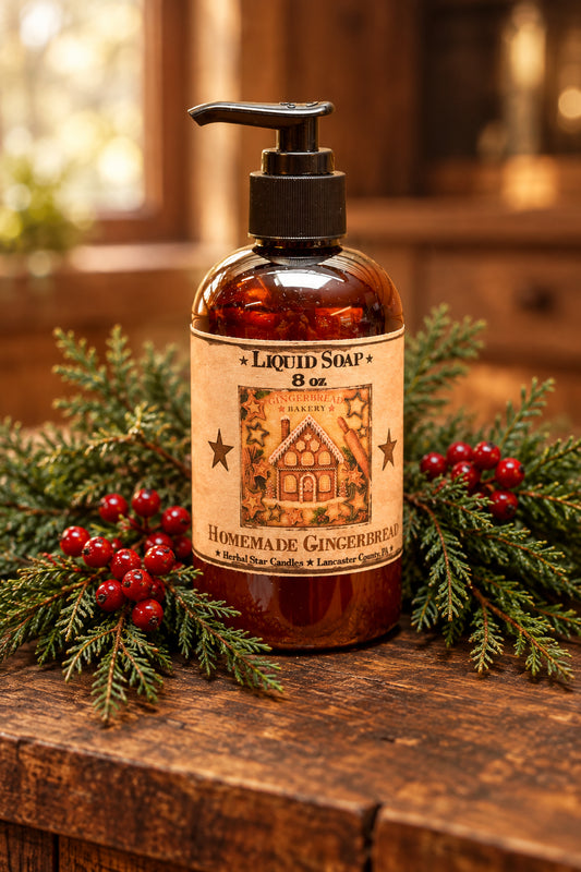 An amber glass pump bottle of liquid soap with a black dispenser and a vintage-style gingerbread label, set on a wooden surface with holiday lights and snow in the background.