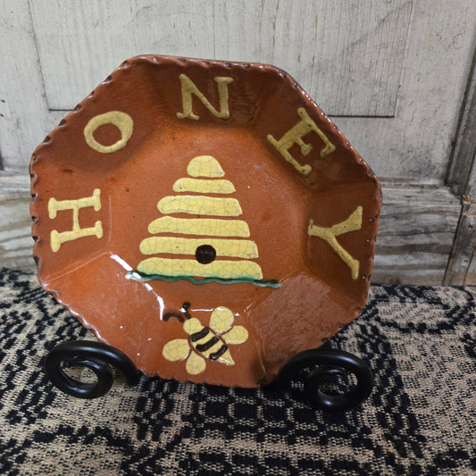 Octagonal redware plate with bee skep motif and the word 'HONEY'