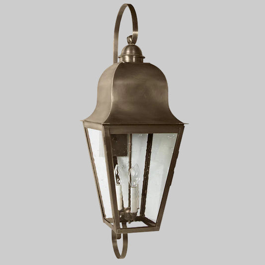 Bronze outdoor wall lantern with clear glass on a gray background