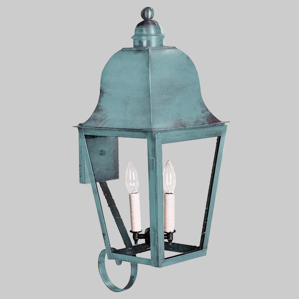 Vintage-style outdoor wall light fixture with a metallic finish on a gray background
