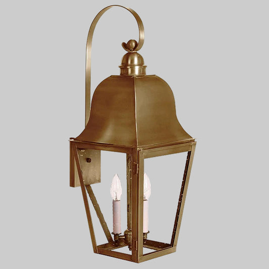 Brass outdoor lantern with two candle-like lights on a gray background