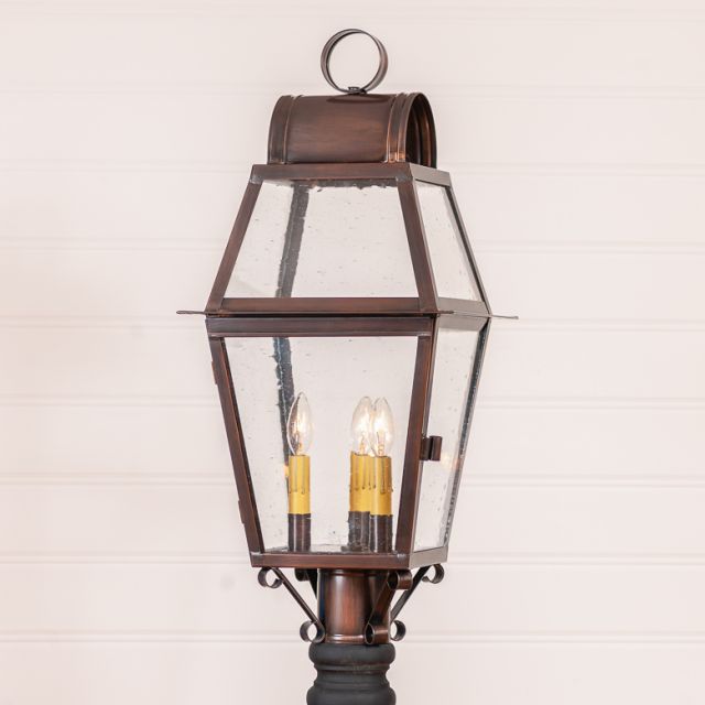Bronze outdoor lamp with clear glass shade on a white background