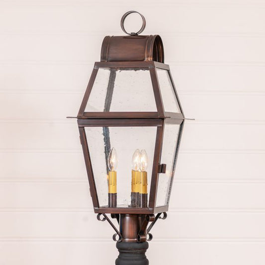 Bronze outdoor lamp with clear glass shade on a white background