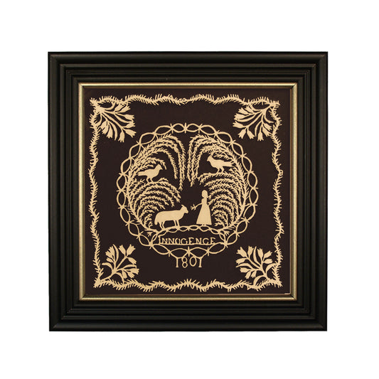 Framed scherenschnitte artwork featuring a historical or farmhouse design with birds, trees, and the year 1801 in the center, enclosed in a black wood frame with gold trim.