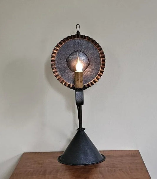 Vintage-style wall sconce with a light bulb on a wooden surface against a beige wall.