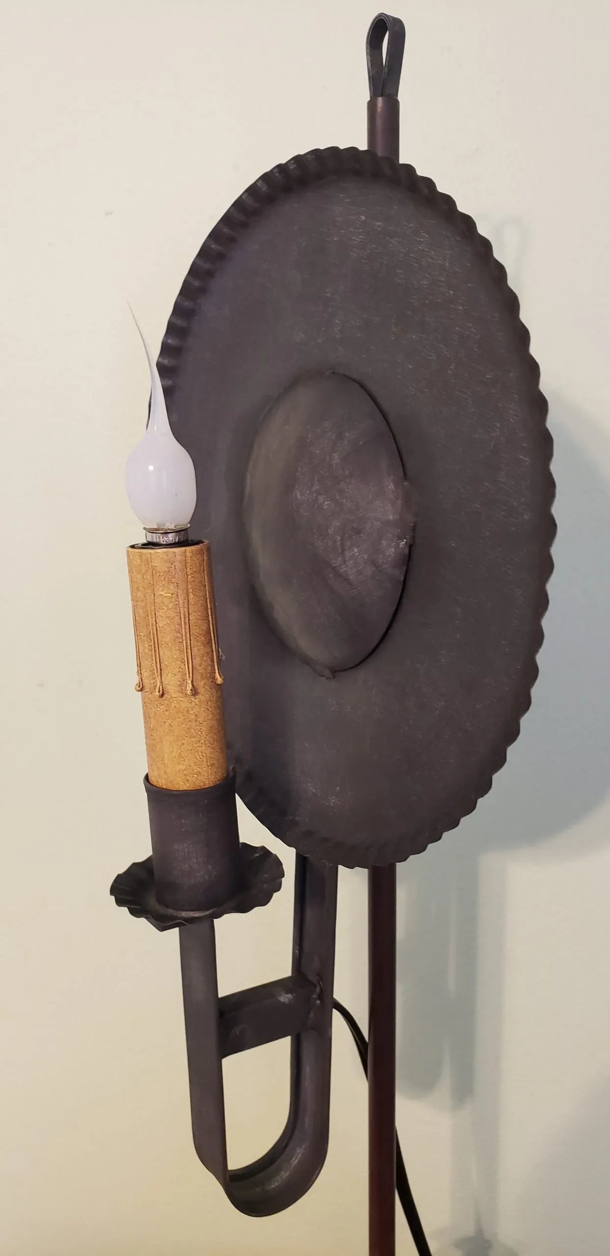 Side view of tin table light with one candelabra bulb.