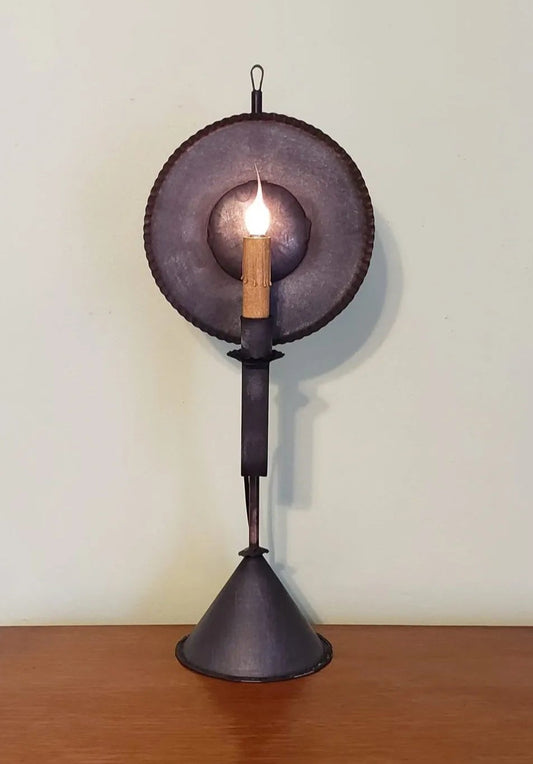 Decorative table lamp with a dark metal design on a wooden surface.