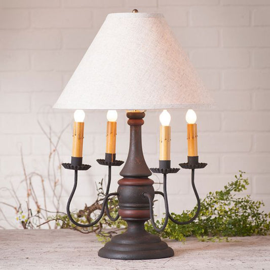 Decorative table lamp with white shade and candle-like lights on a wooden surface.