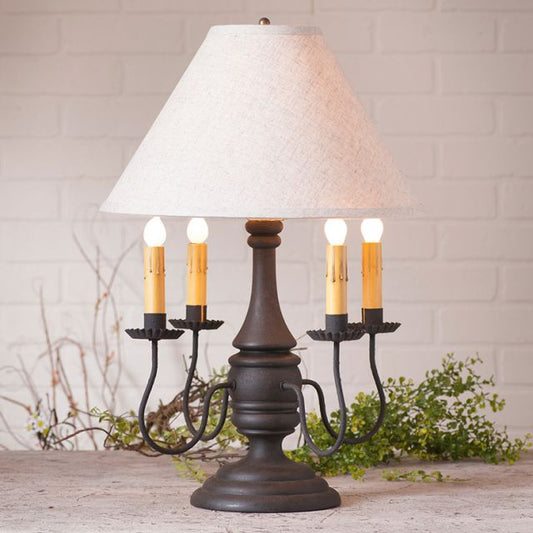 Decorative table lamp with white shade and candle-like lights on a wooden surface.