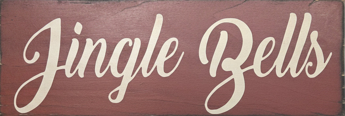 Wooden sign with 'Jingle Bells' text on a background of greenery
