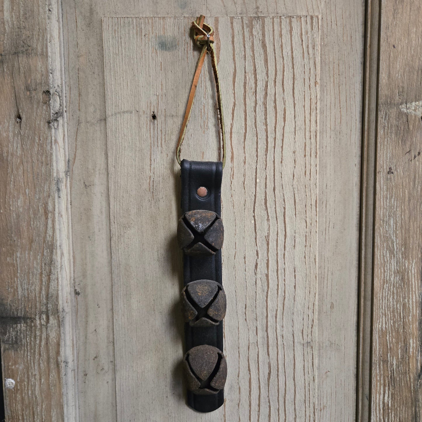 Decorative leather strap with metal accents on a wooden surface
