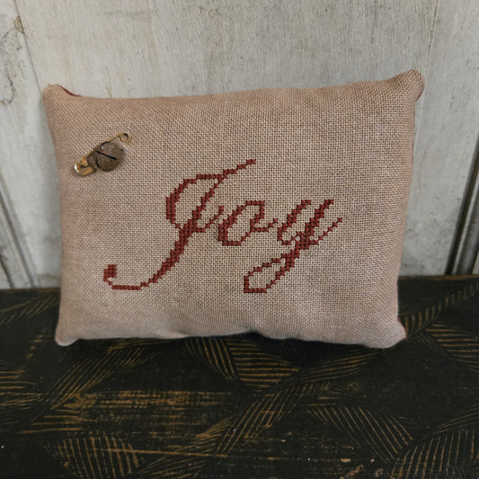 Textured pillow with embroidered design on a neutral background