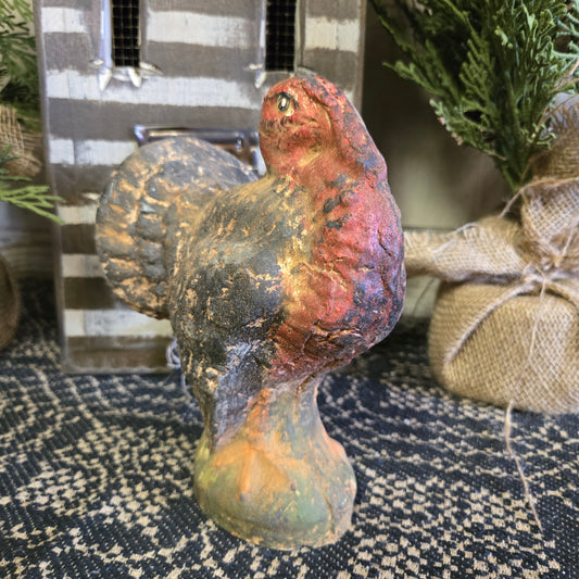 A handcrafted multicolored chalkware turkey decoration with a rustic finish.