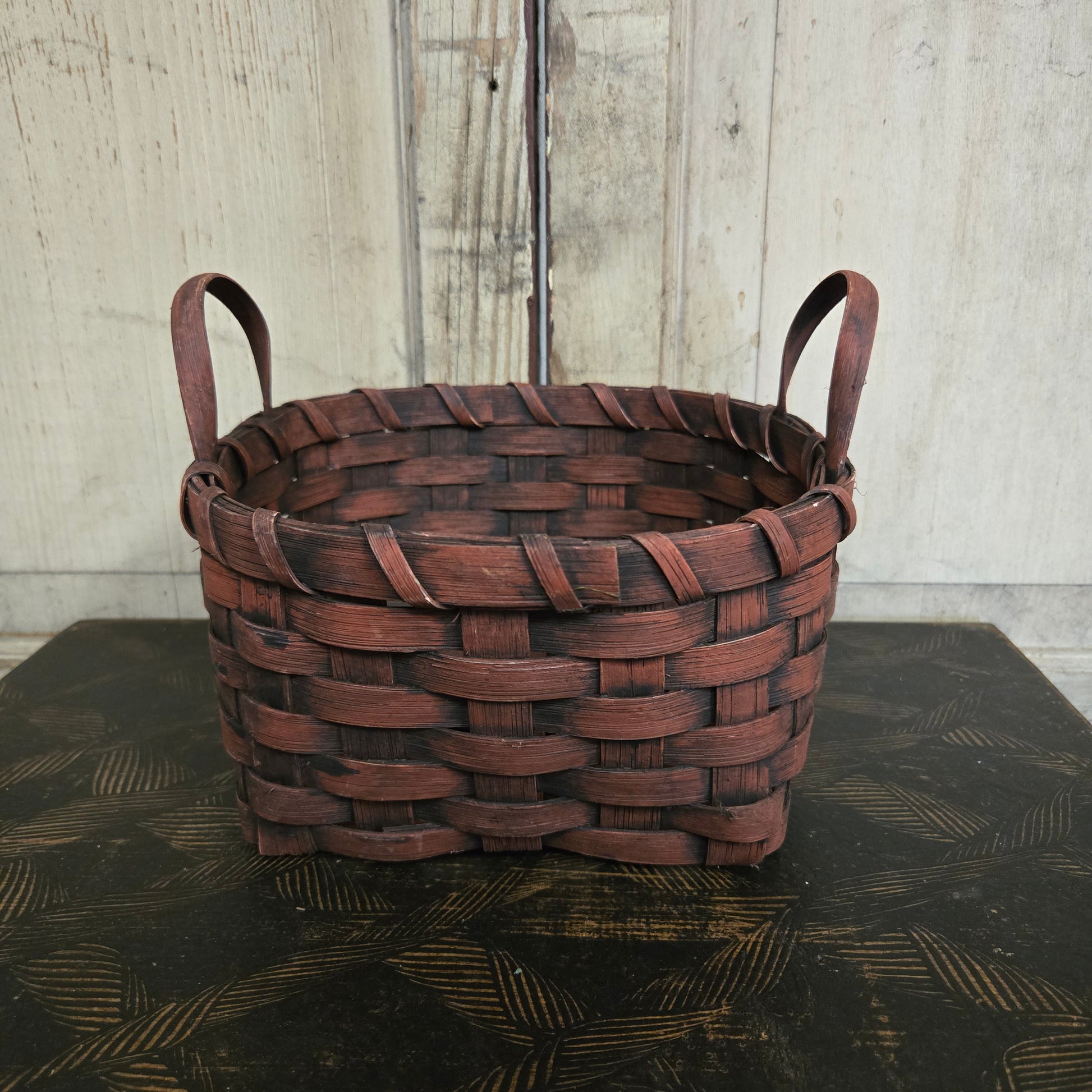 Woven burgundy basket on a textured surface