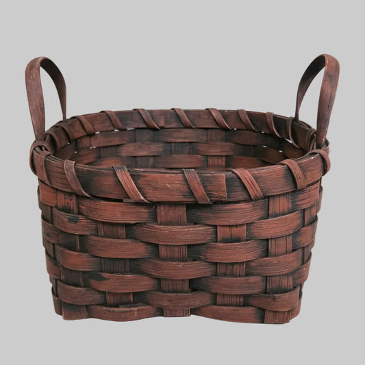 Woven burgundy basket on a textured surface