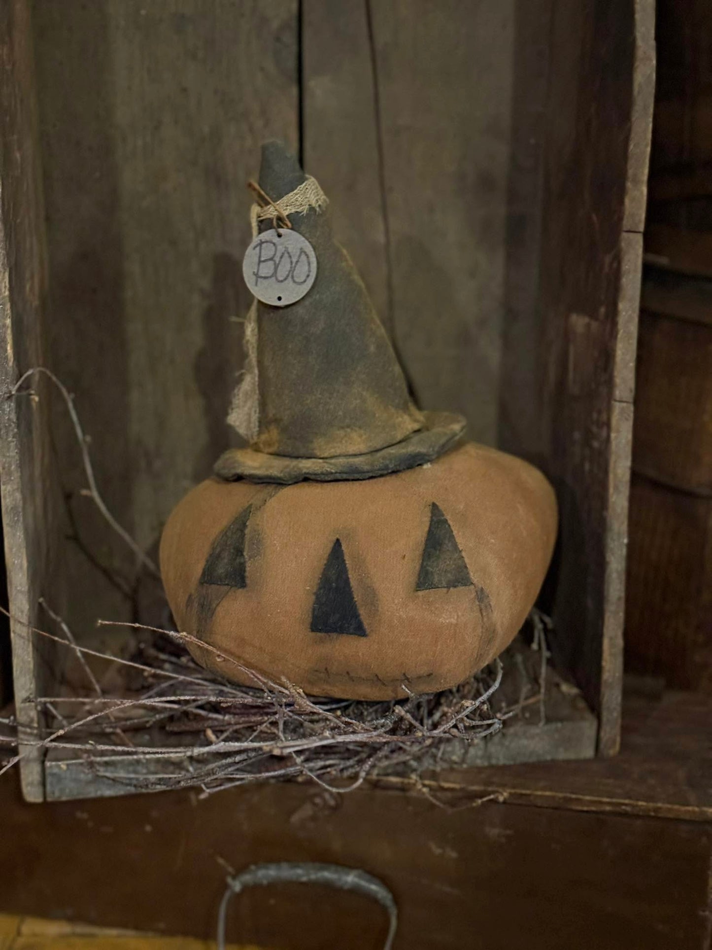 Decorative pumpkin with a witch hat and 'BOO' tag on a rustic background