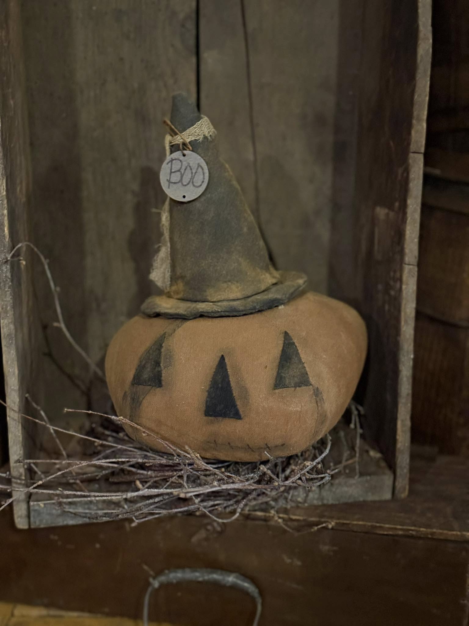Decorative pumpkin with a witch hat and 'BOO' tag on a rustic background
