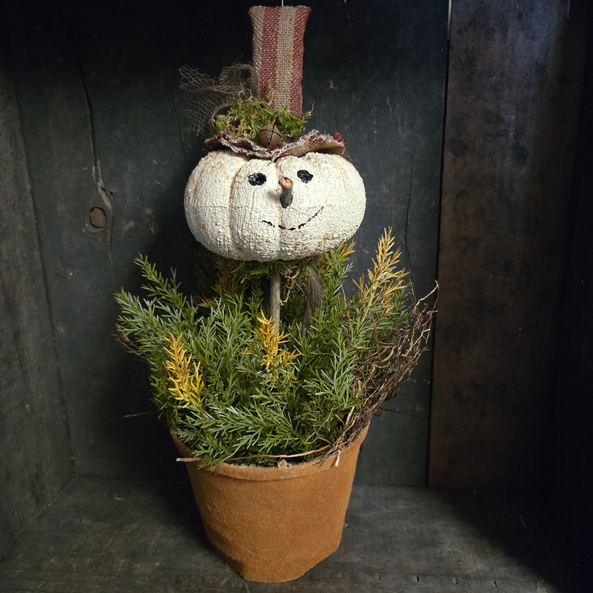 Decorative pumpkin with greenery on a dark surface