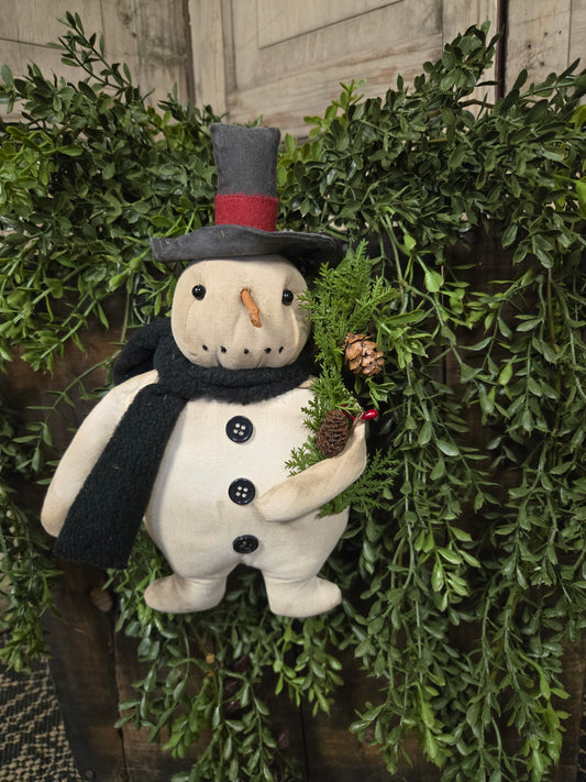 Decorative snowman figurine with a scarf on a green wreath