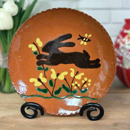 Ceramic wall hook with hand-painted design of a hand, butterfly, and flowers on a textured surface.