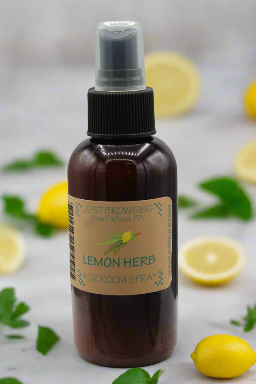 A 4oz bottle of Lemon Herb Room Spray with a mist spray top, labeled as 'Just Browsing' brand product surrounded by lemons and herbs.