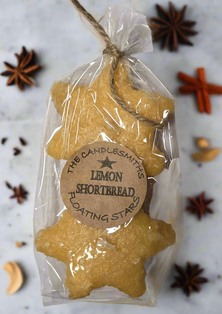 Packaged lemon-scented floating candles shaped like stars, displayed in a clear plastic wrapping with a label that reads 'The Candlesmiths Lemon Shortbread'.