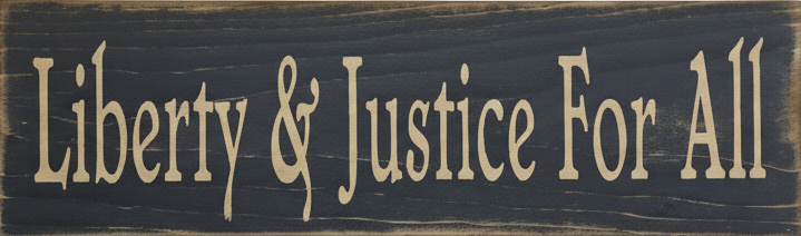 Wooden sign with 'Liberty & Justice For All' text on a dark background
