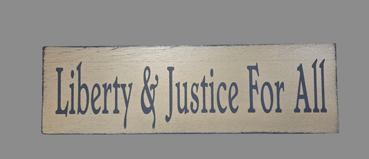 Wooden sign with 'Liberty & Justice For All' text on a gray background