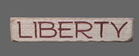 Weathered cream wood sign with the word "LIBERTY" painted in red